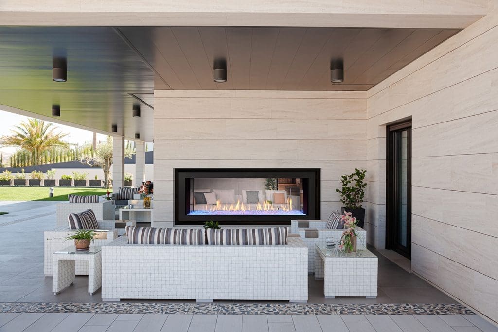 Outdoor living example - fireplace built into the outside wall of a house next to patio furniture
