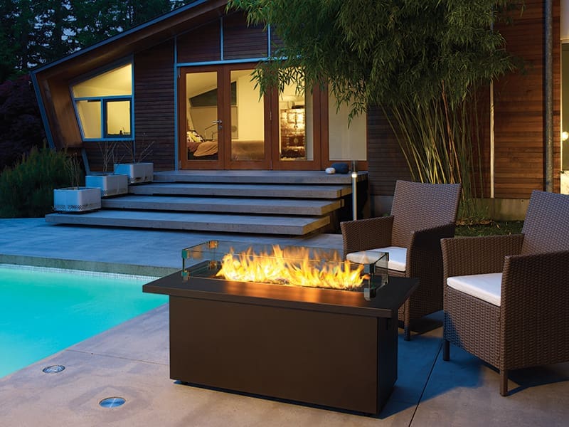 Outdoor living example - free standing fireplace next to patio furniture and a BBQ