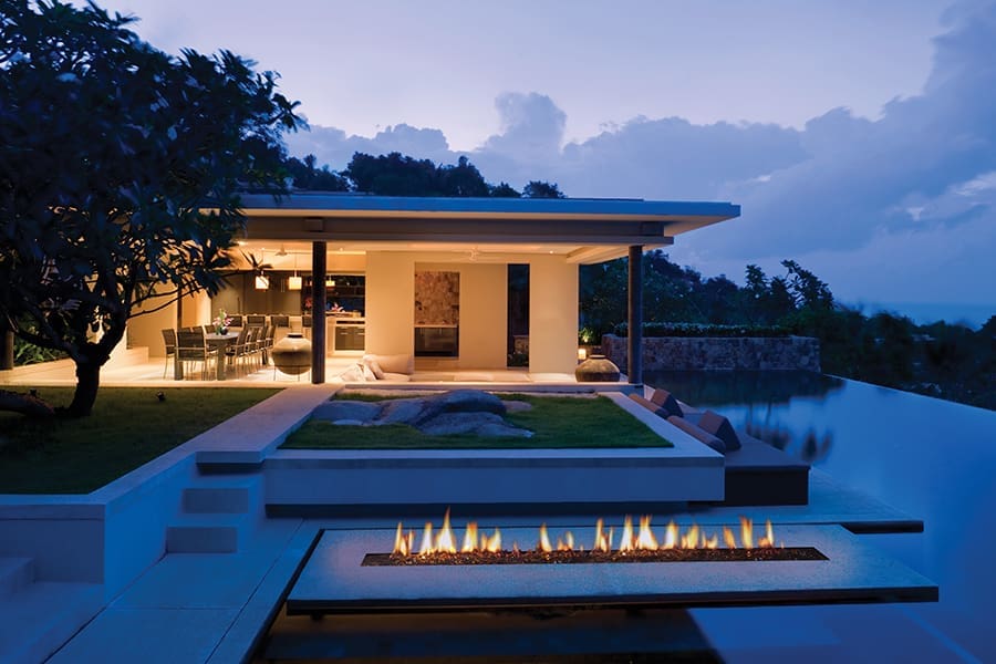 Outdoor living example - free standing fireplace next to patio furniture and a BBQ