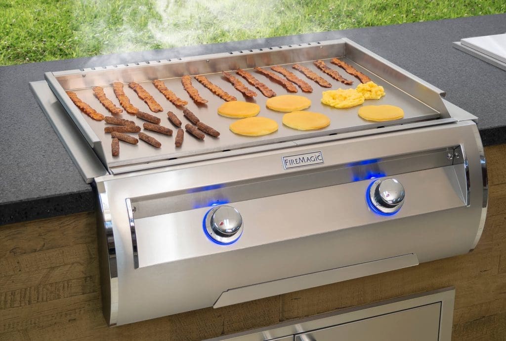 Outdoor Kitchen grill with bacon, sausage, pancakes, and eggs being grilled