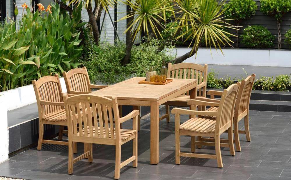 6 patio chairs set up around a patio table in a backyard