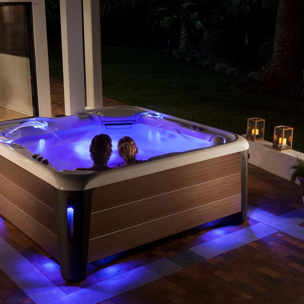 Couple in a hot tub outside of their home