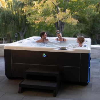 A family in a Hot Spring Highlife Collection hot tub with water feature
