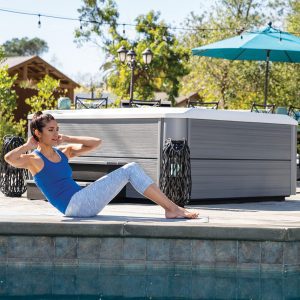 Woman exercising in front of a stylish hot tub